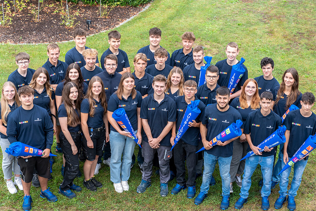 Gruppenfoto aller Auszubildenden von Schabmüller in blauen Unternehmens-Shirts mit Schultüten