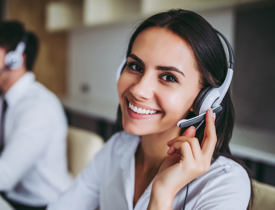 Junge Frau mit Headset lächelt in die Kamera